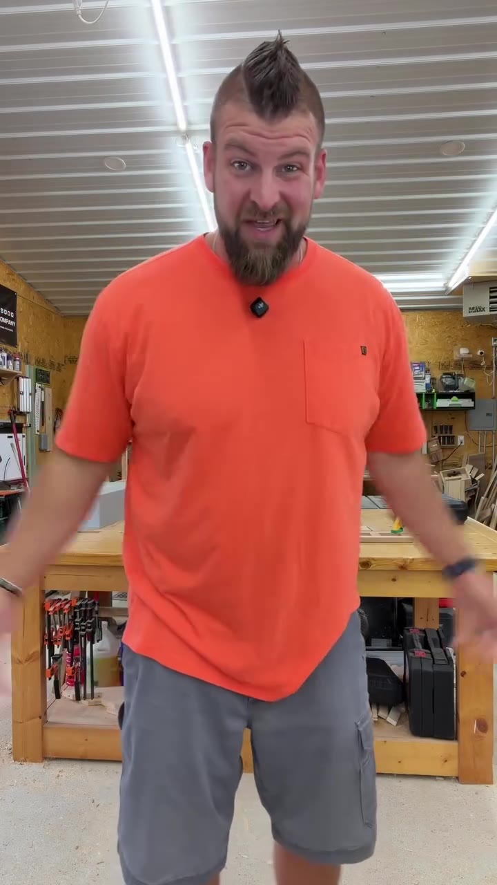 Bigger man standing in a sized up orange standard tee that hangs like a tent